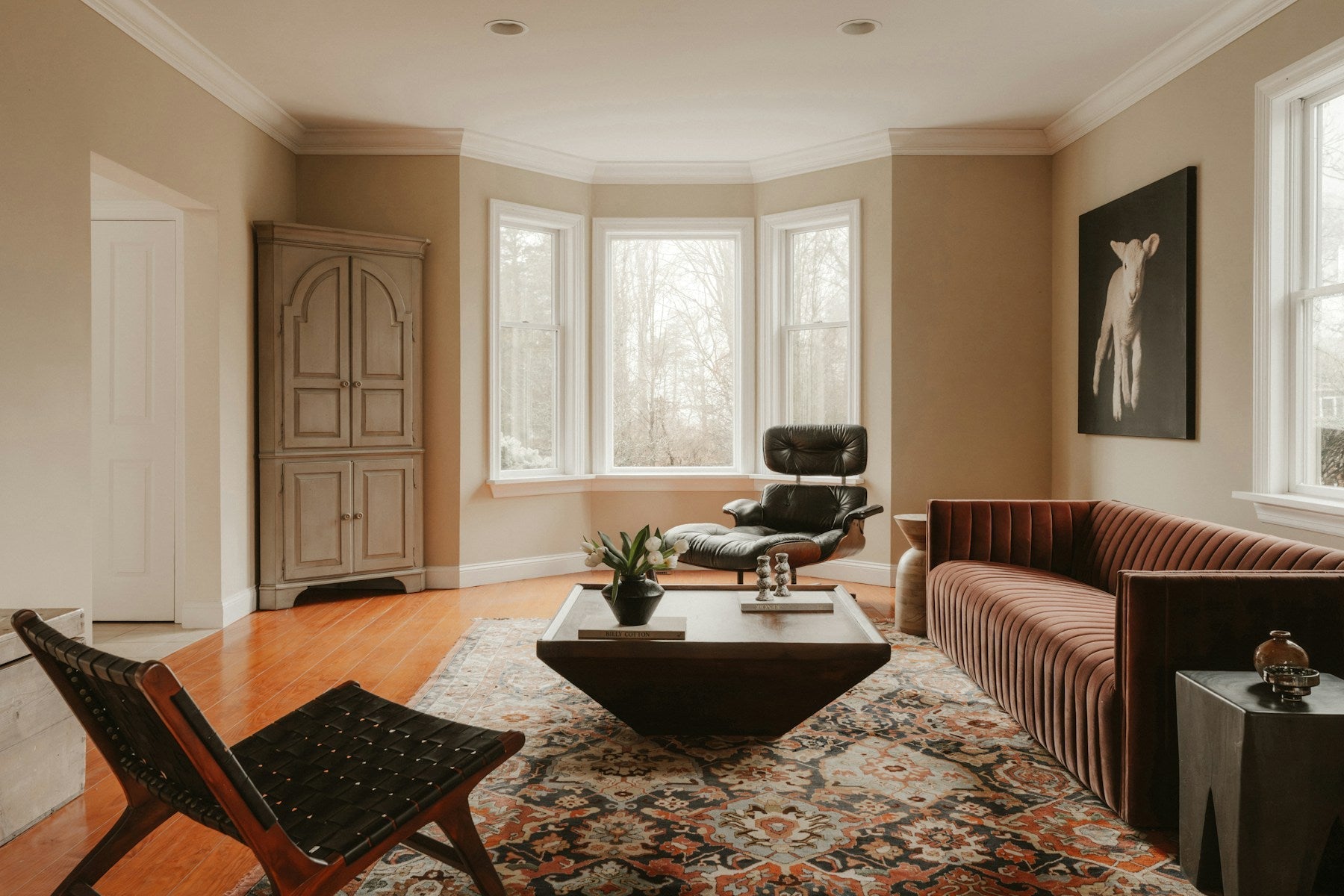 Traditional-patterned rug under contemporary seating in a bright living room