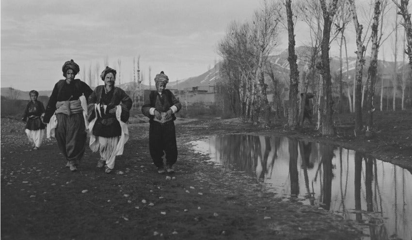 Kurdish men walking along a flooded path in Soujbulak in winter, 1914