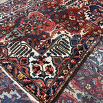 Folded corner of Bakhtiari rug showing the wool face, cotton foundation and reverse-side pattern.