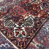 Folded corner of Bakhtiari rug showing the wool face, cotton foundation and reverse-side pattern.