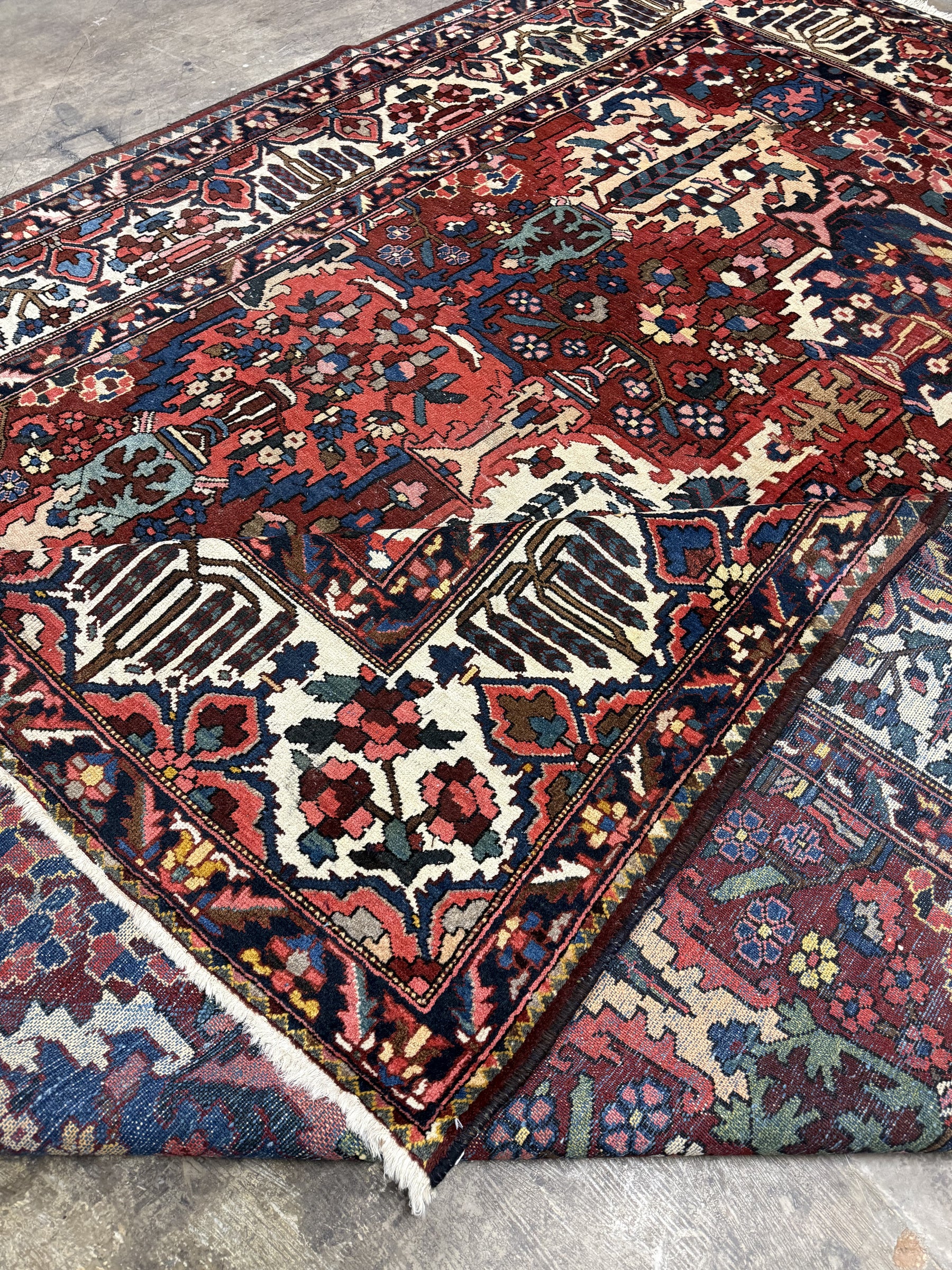 Folded corner of Bakhtiari rug showing the wool face, cotton foundation and reverse-side pattern.