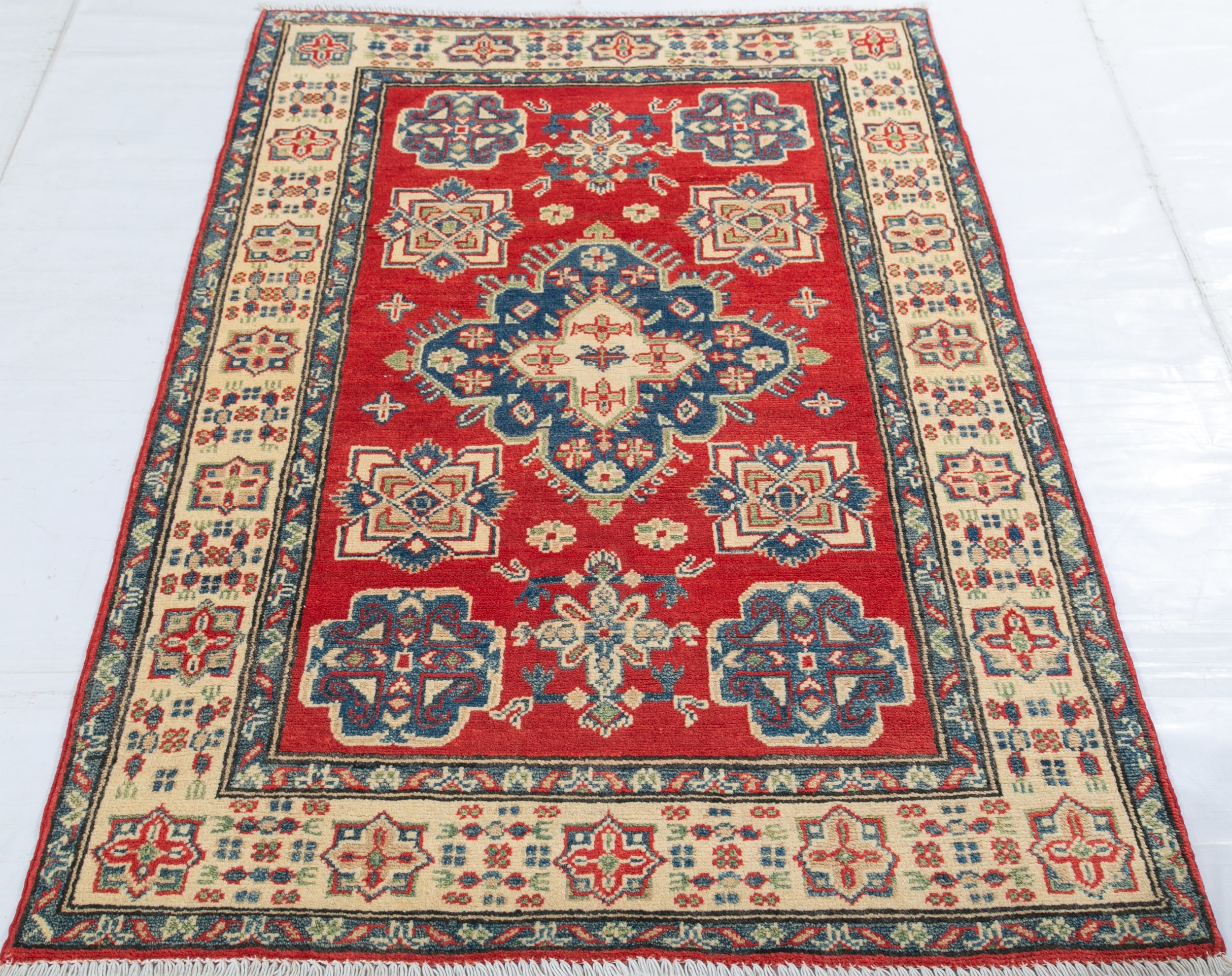 Full view from a low angle of red & blue Kazak-inspired wool rug 15499.