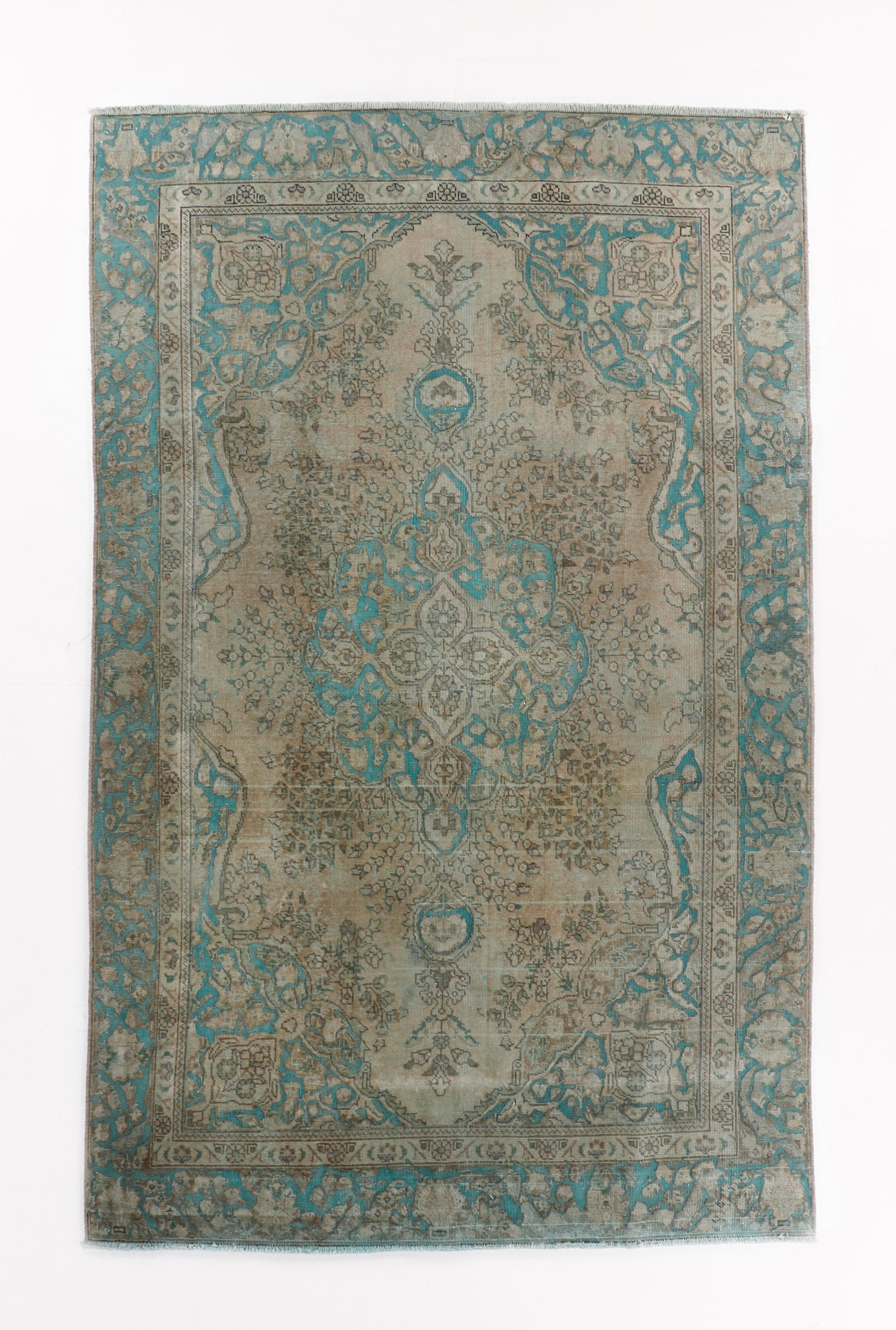 Rectangular Persian Tabriz rug in muted beige and blue with intricate floral medallion and border detailing.