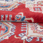 Folded edge and wool pile of red & ivory Kazak-inspired wool rug 21424.