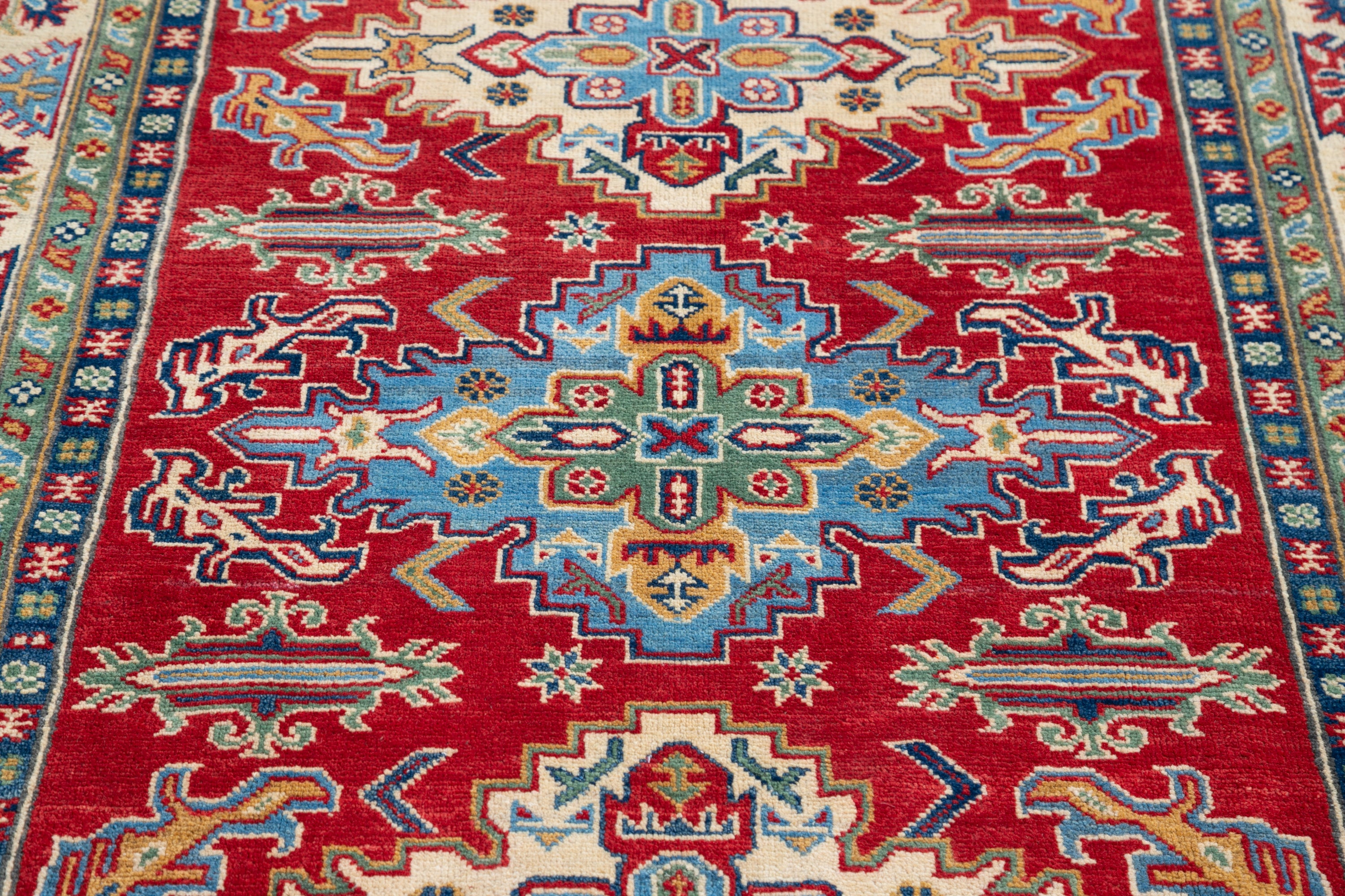 Pattern detail of red & green Kazak-inspired wool rug 21525.