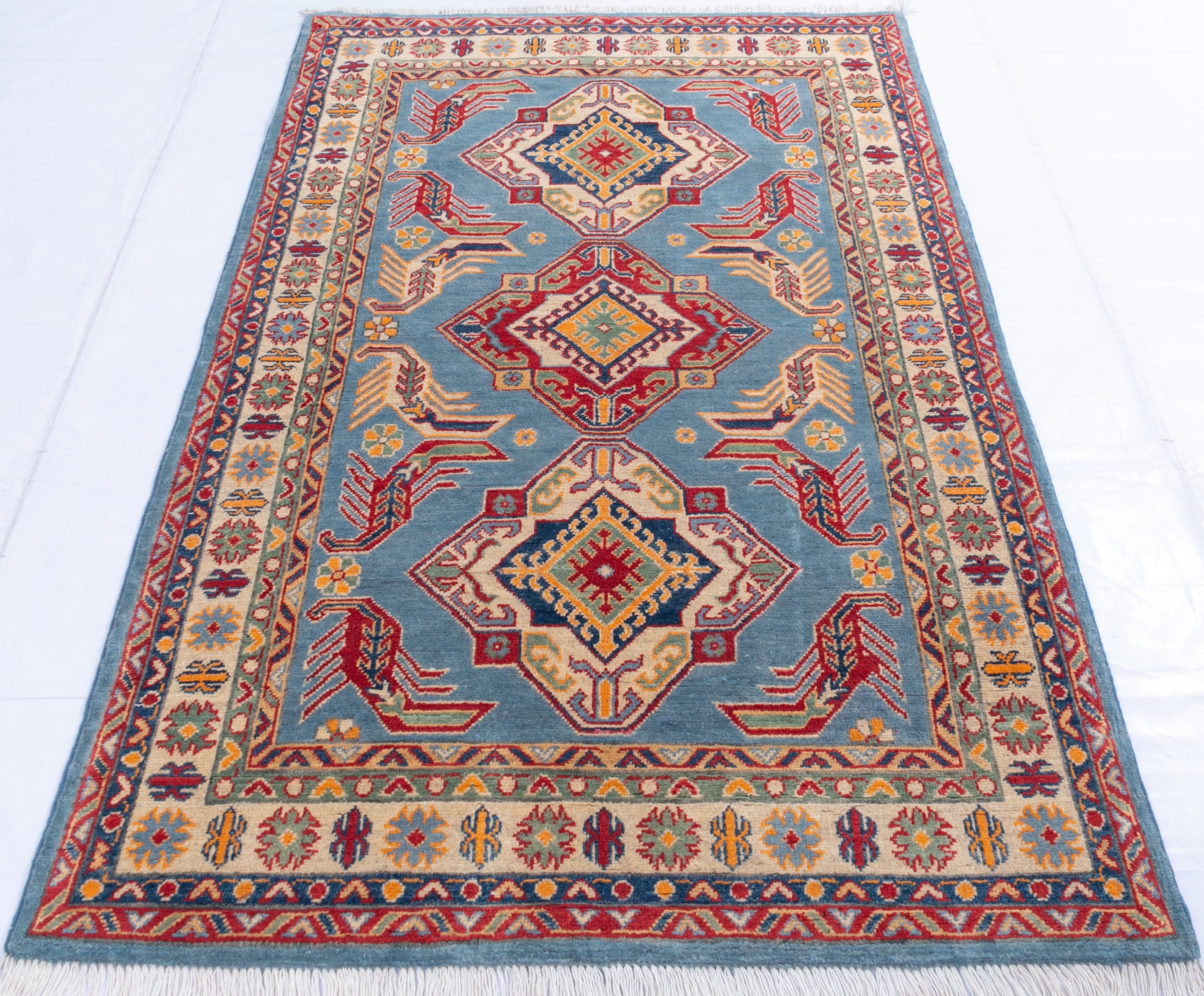 Full view from a low angle of blue & red Kazak-inspired wool rug 21980.