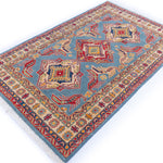 Full view at an angle of blue & red Kazak-inspired wool rug 21980.