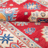 Folded edge and wool pile of red & ivory Kazak-inspired wool rug 21984.