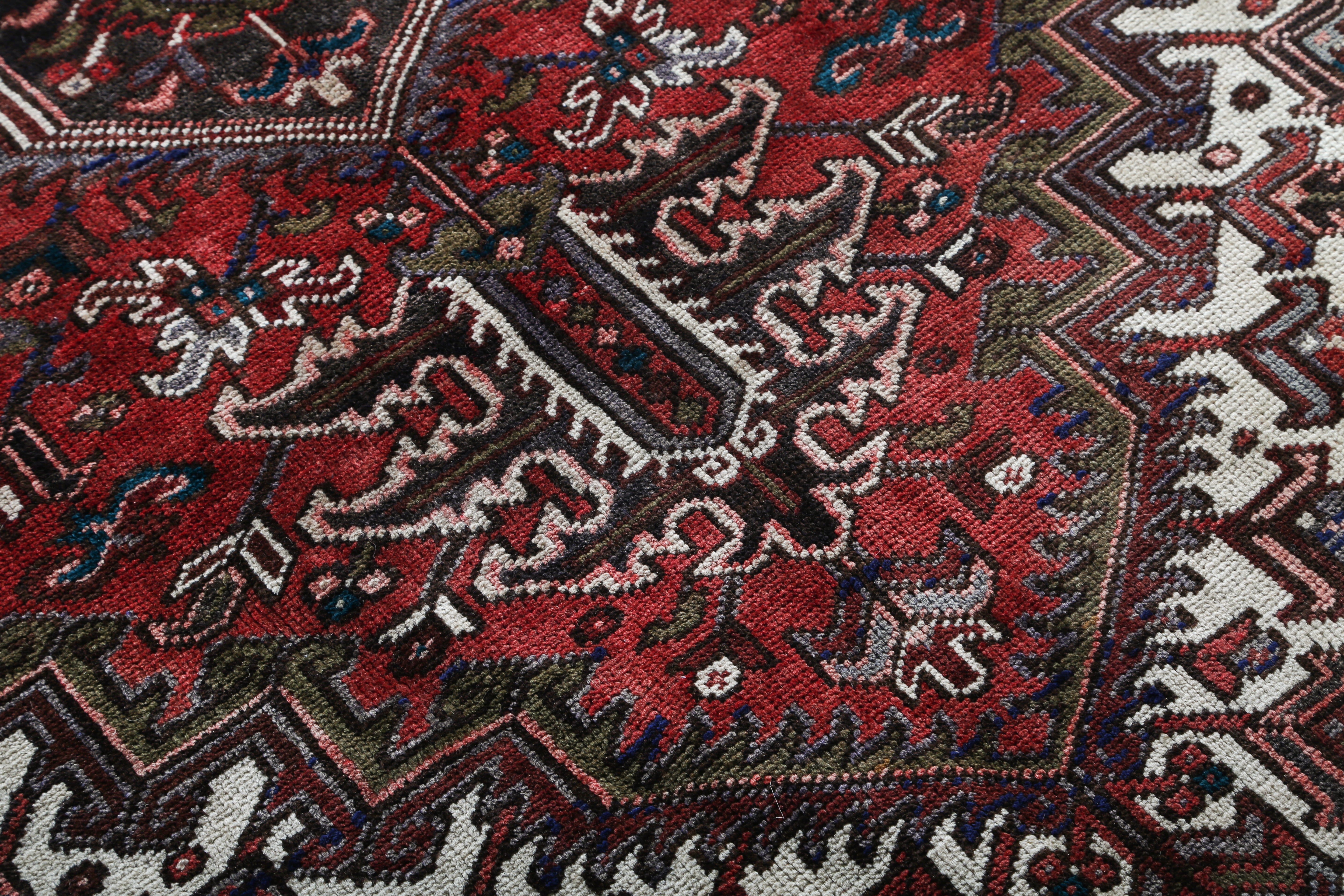 Persian Heriz rug with red, navy, and white geometric patterns