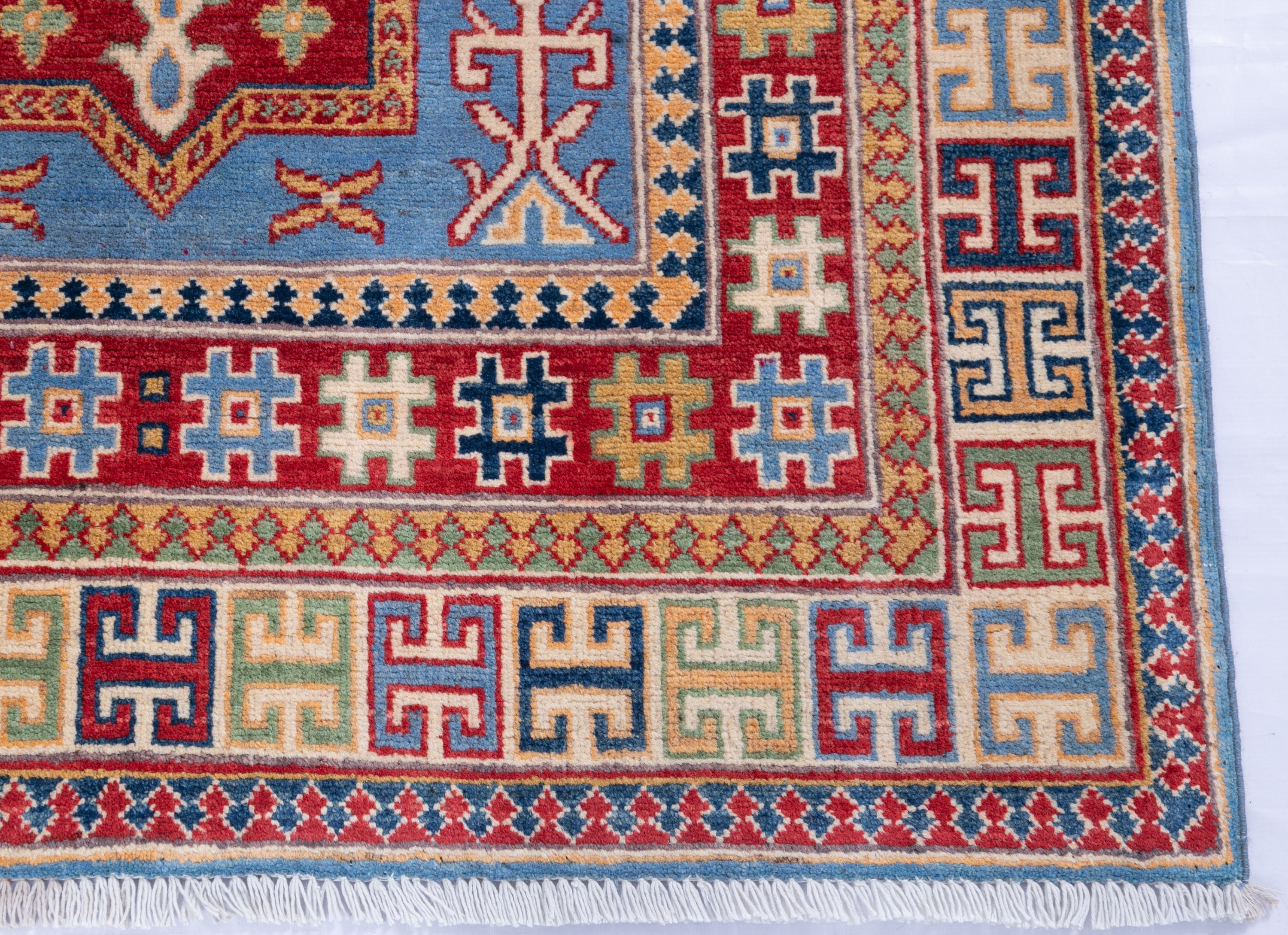 Border and edge detail of blue & red Kazak-inspired wool rug 22077.