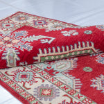 Folded edge and wool pile of red & ivory Kazak-inspired wool rug 23375.