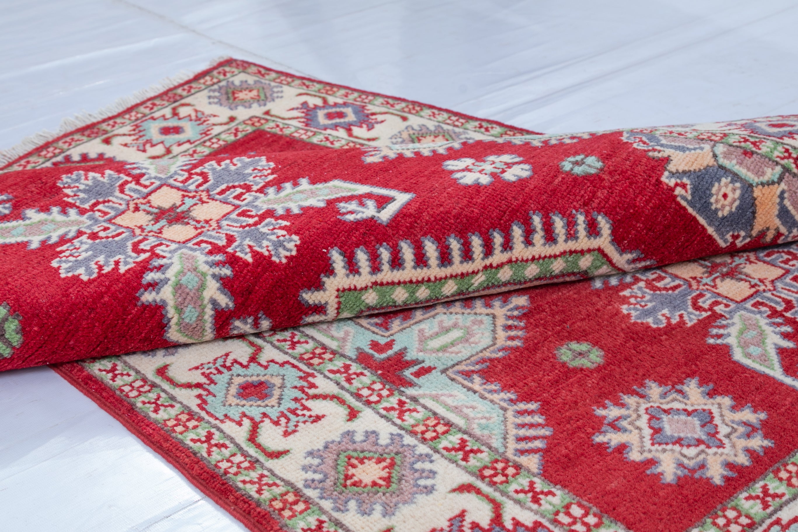 Folded edge and wool pile of red & ivory Kazak-inspired wool rug 23375.