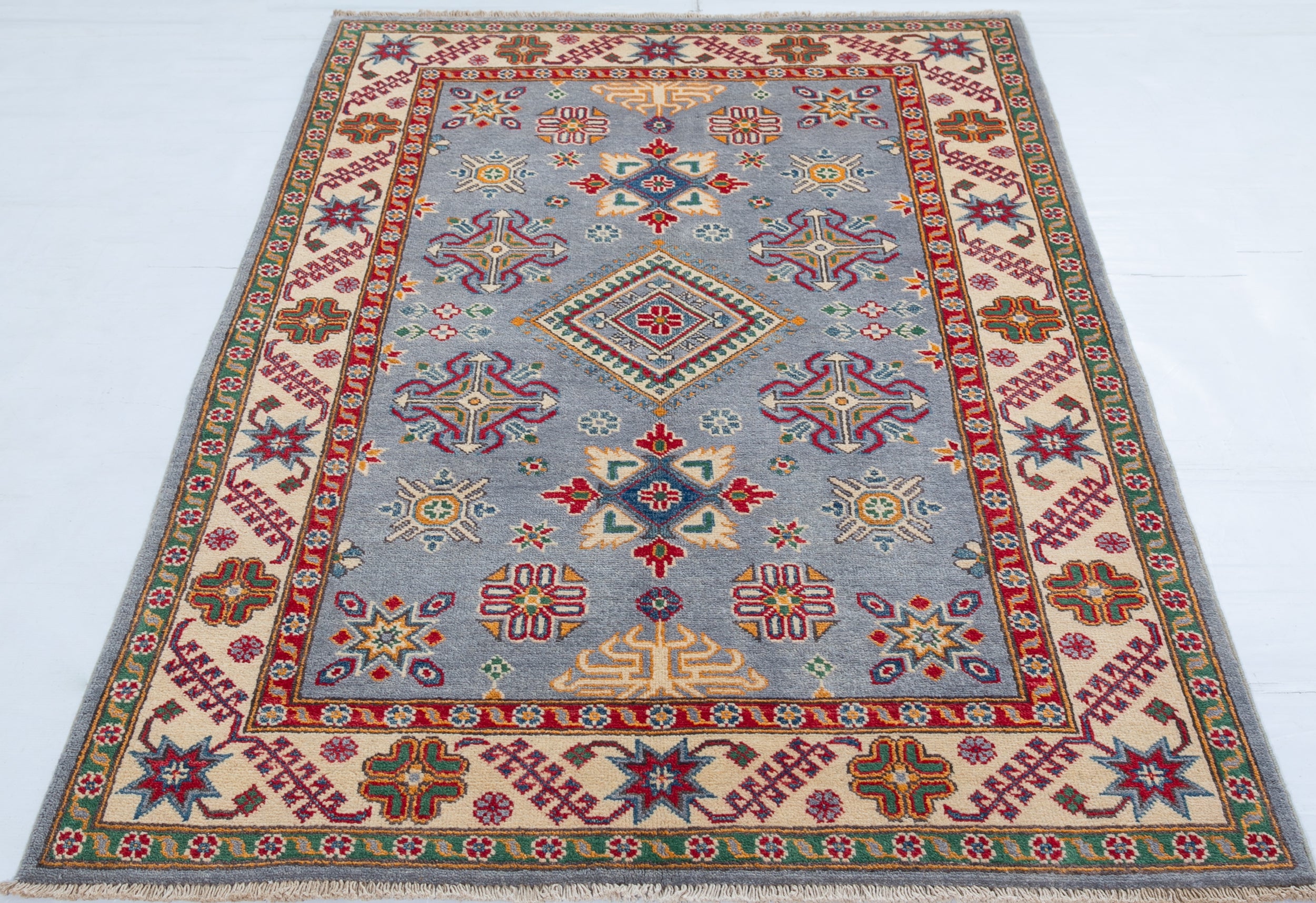 Full view from a low angle of blue & red Kazak-inspired wool rug 27430.