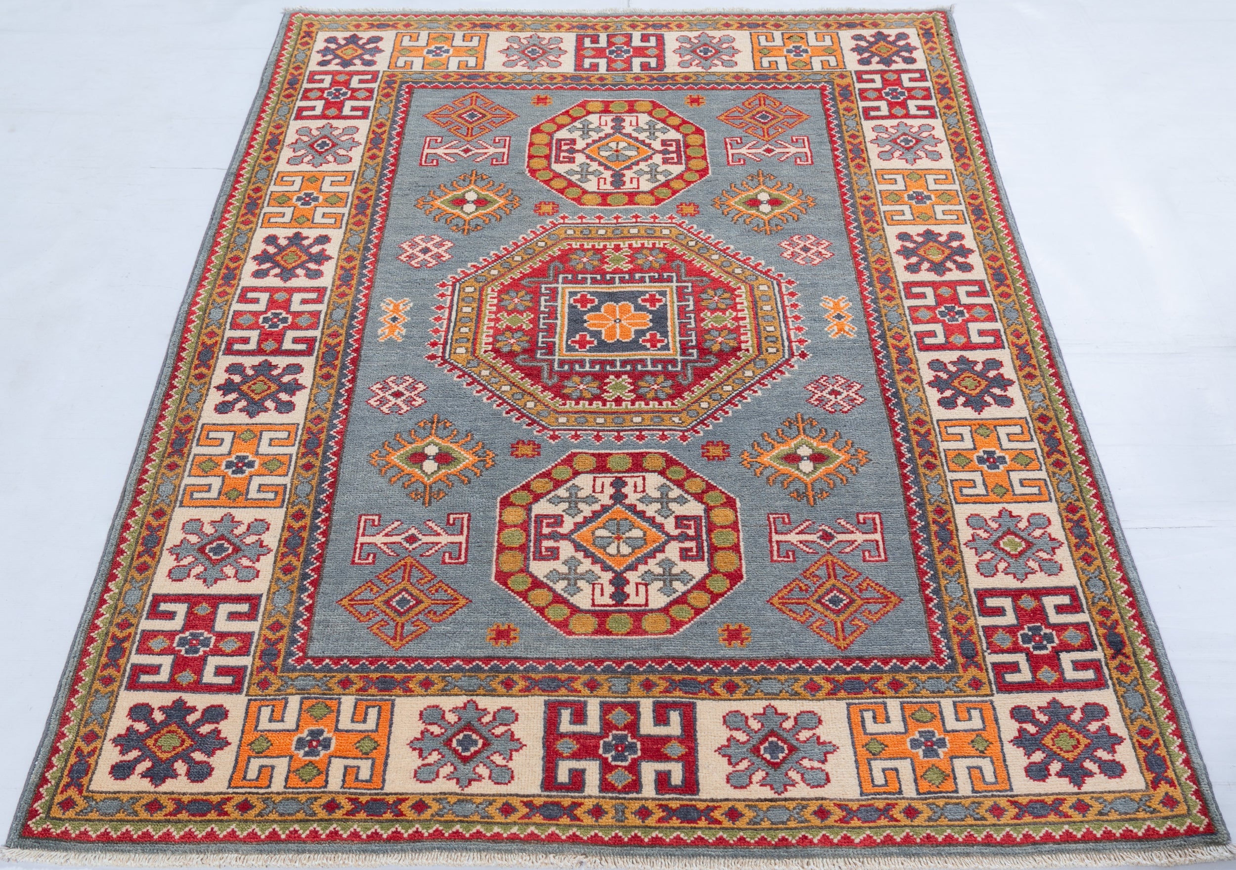 Full view from a low angle of blue & red Kazak-inspired wool rug 27433.