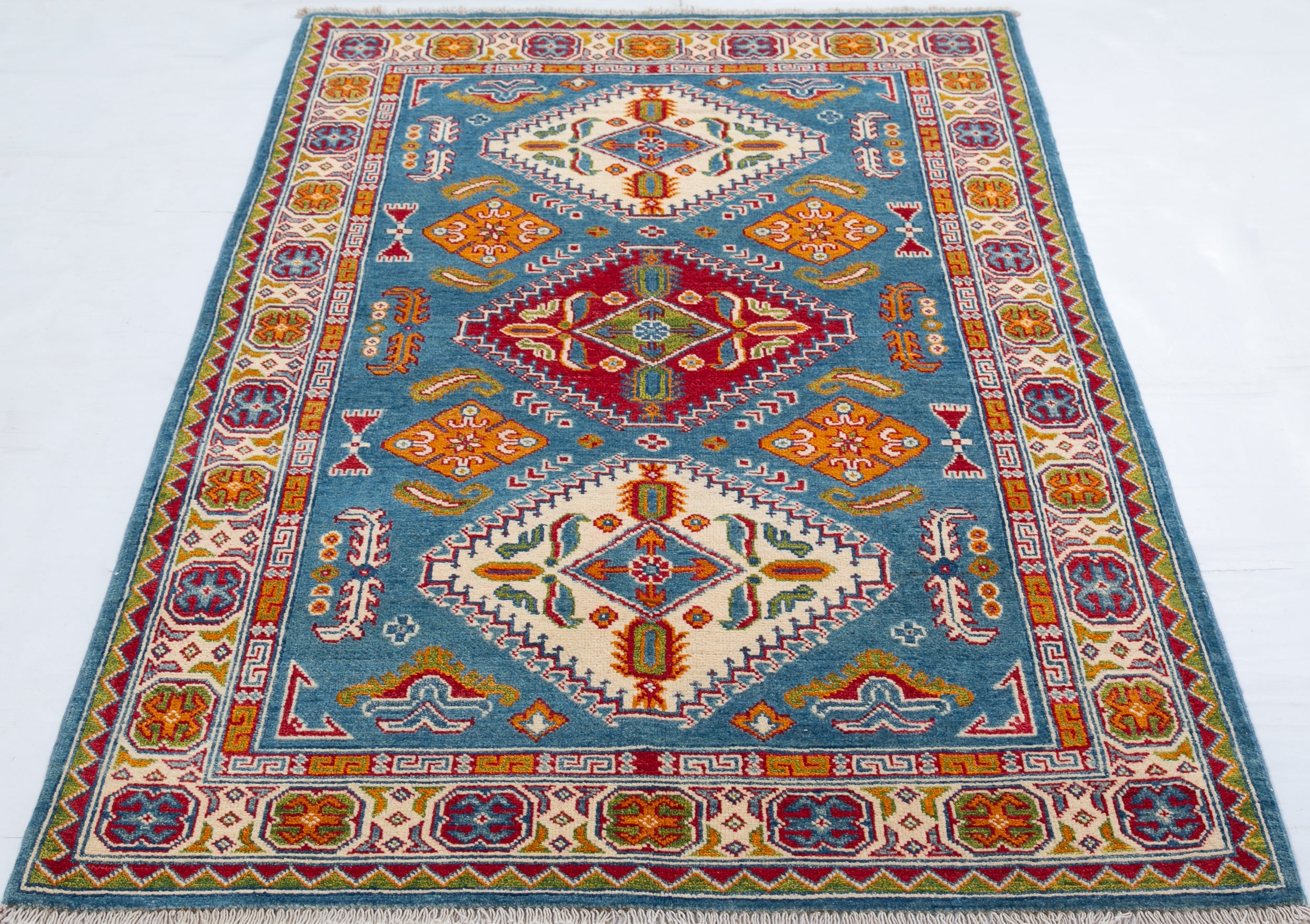 Full view from a low angle of blue & red Kazak-inspired wool rug 27434.