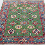 Full view from a low angle of green & red Kazak-inspired wool rug 29347.