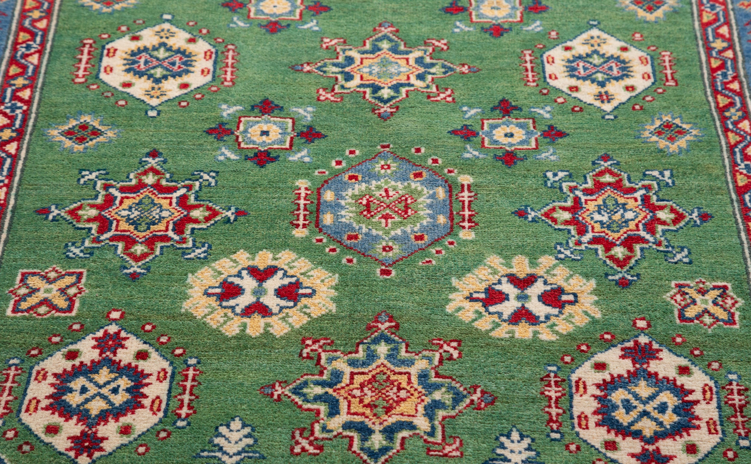 Pattern detail of green & red Kazak-inspired wool rug 29347.