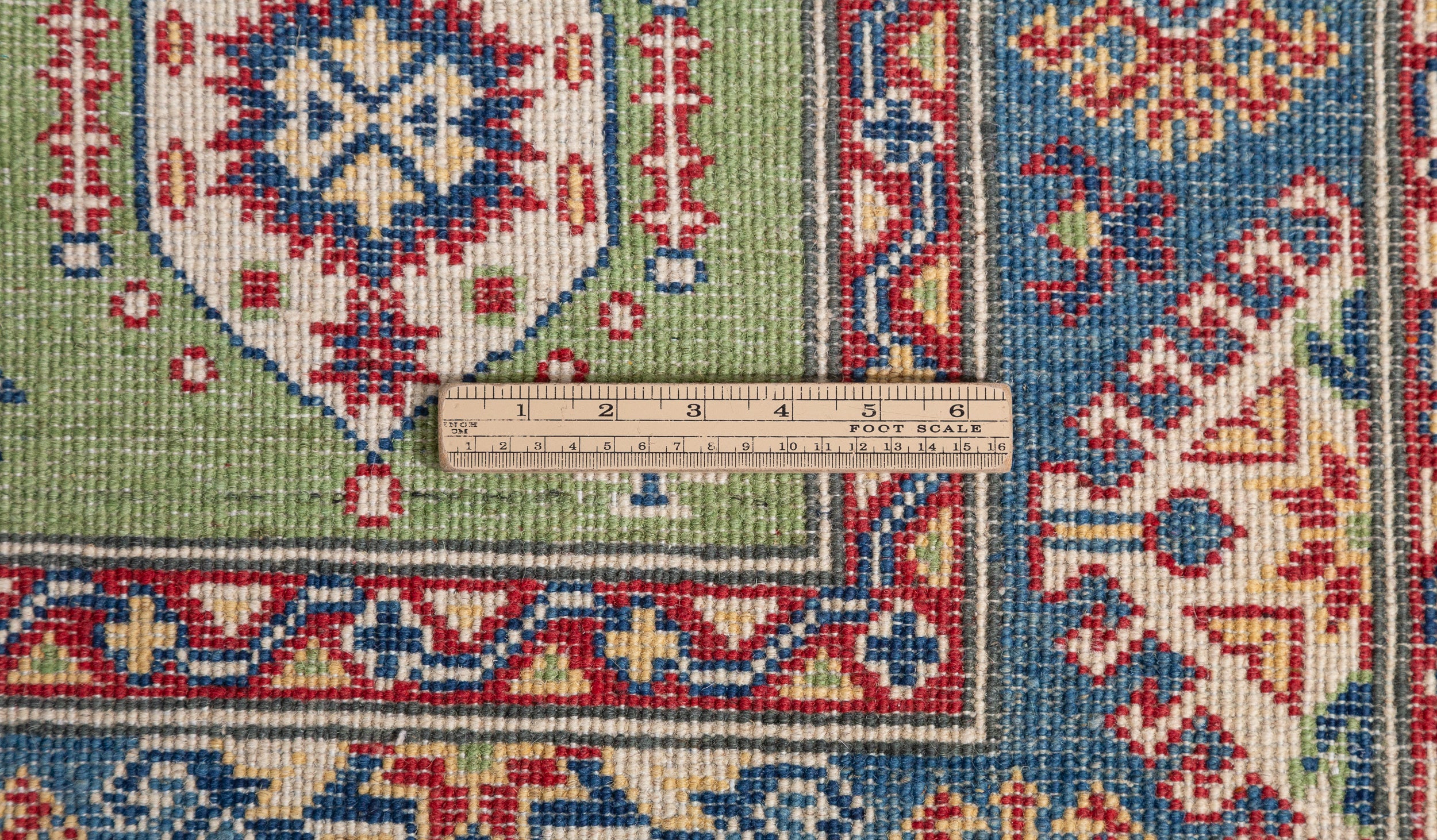 Wool pile close-up of green & red Kazak-inspired wool rug 29347.