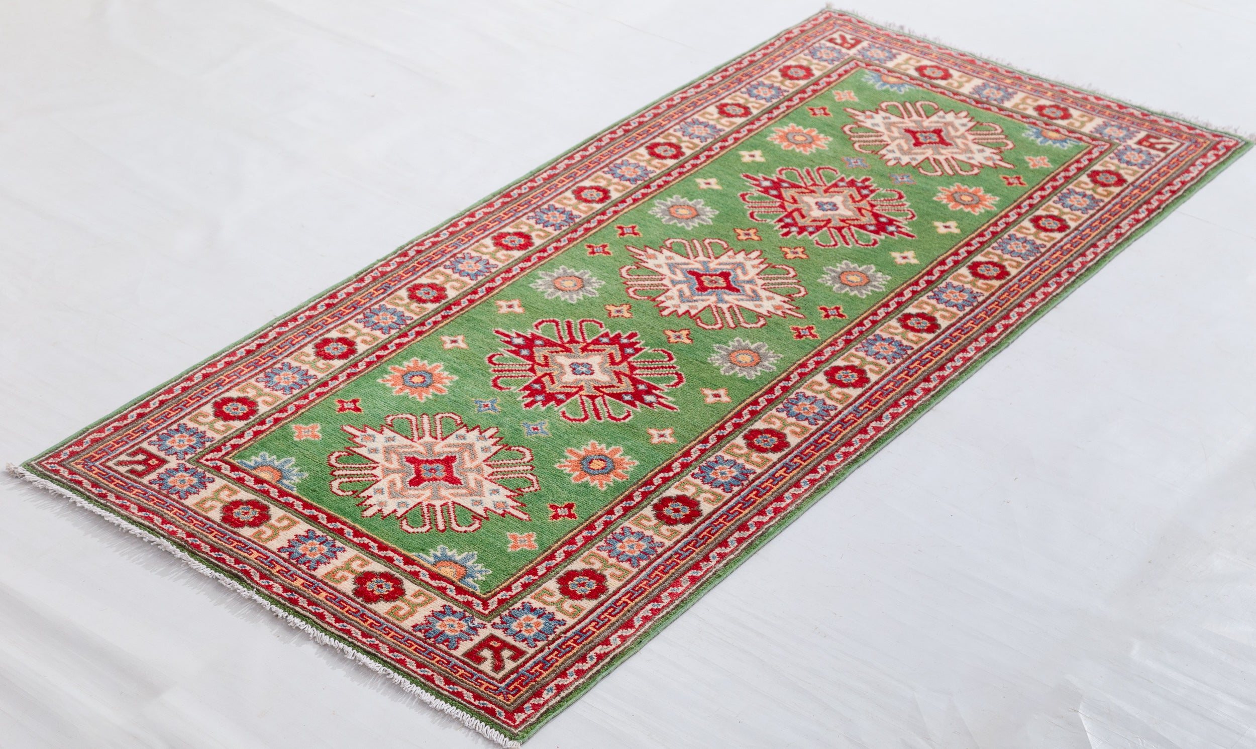 Full view at an angle of green & red Kazak-inspired wool runner 29353.