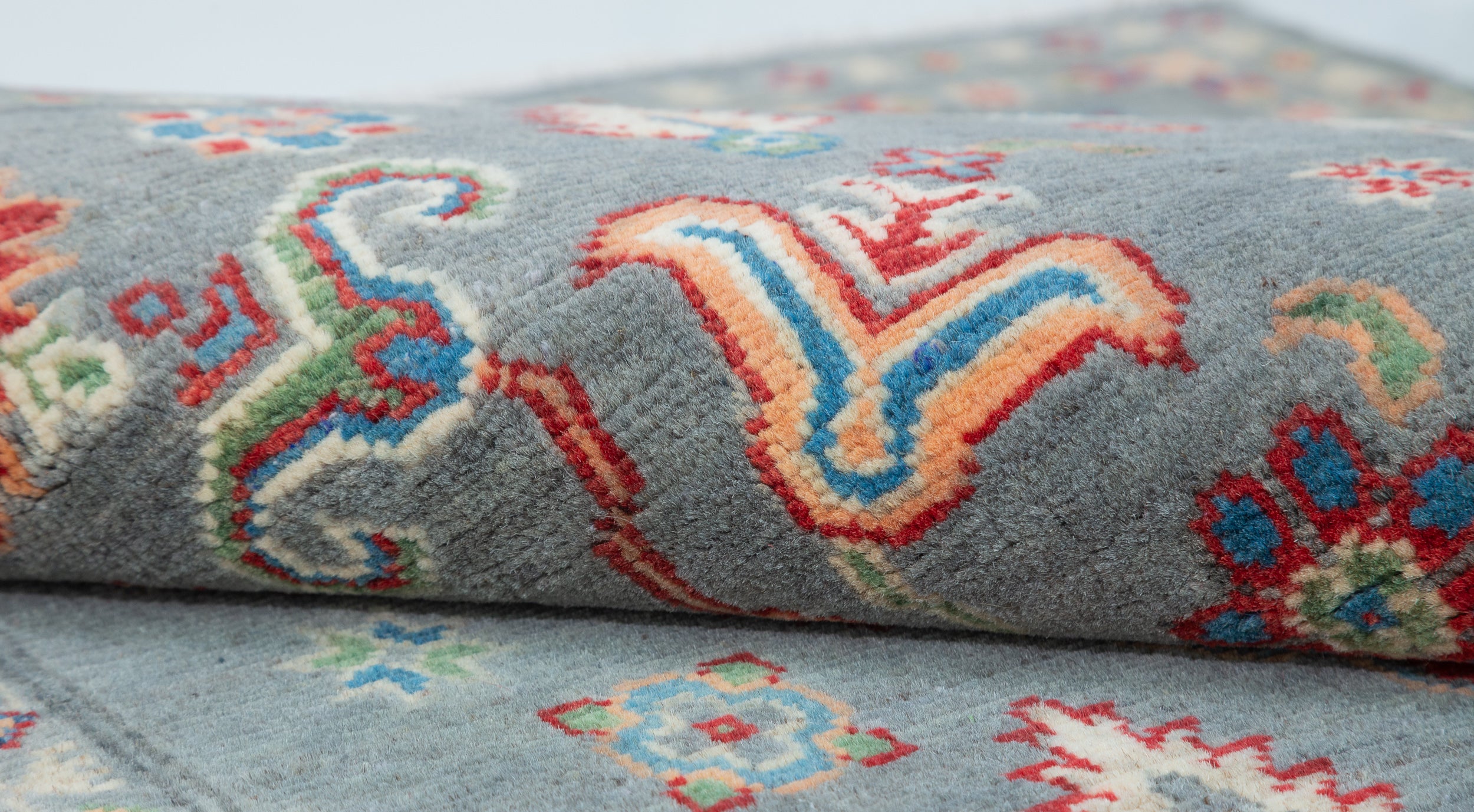 Folded edge and wool pile of blue & ivory Kazak-inspired wool rug 29645.