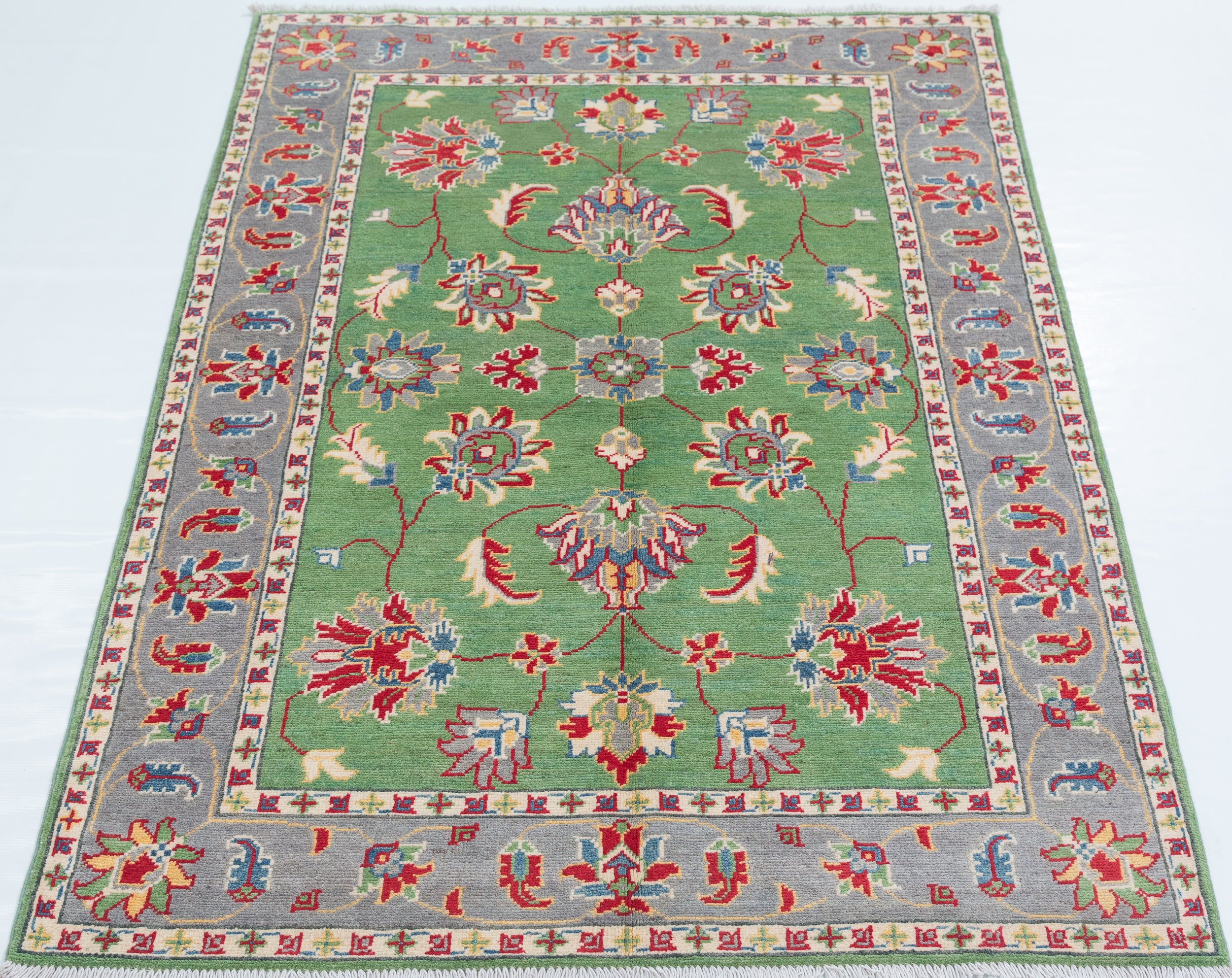 Full view from a low angle of green & ivory Kazak-inspired wool rug 29646.