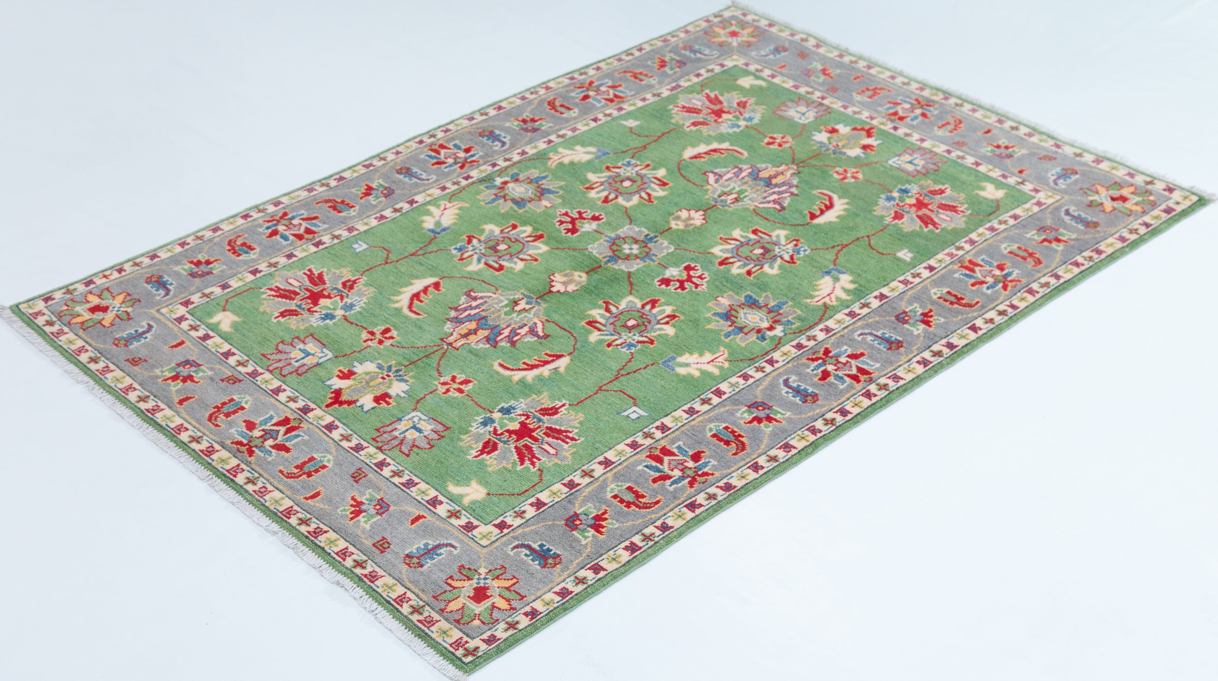 Full view at an angle of green & ivory Kazak-inspired wool rug 29646.