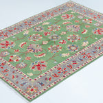 Full view at an angle of green & ivory Kazak-inspired wool rug 29646.