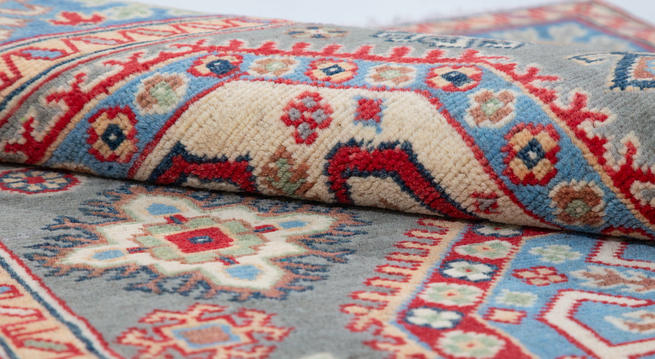 Folded edge and wool pile of blue & ivory Kazak-inspired wool rug 29647.