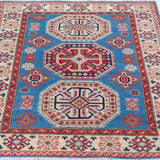 Full view from a low angle of blue & red Kazak-inspired wool rug 29648.