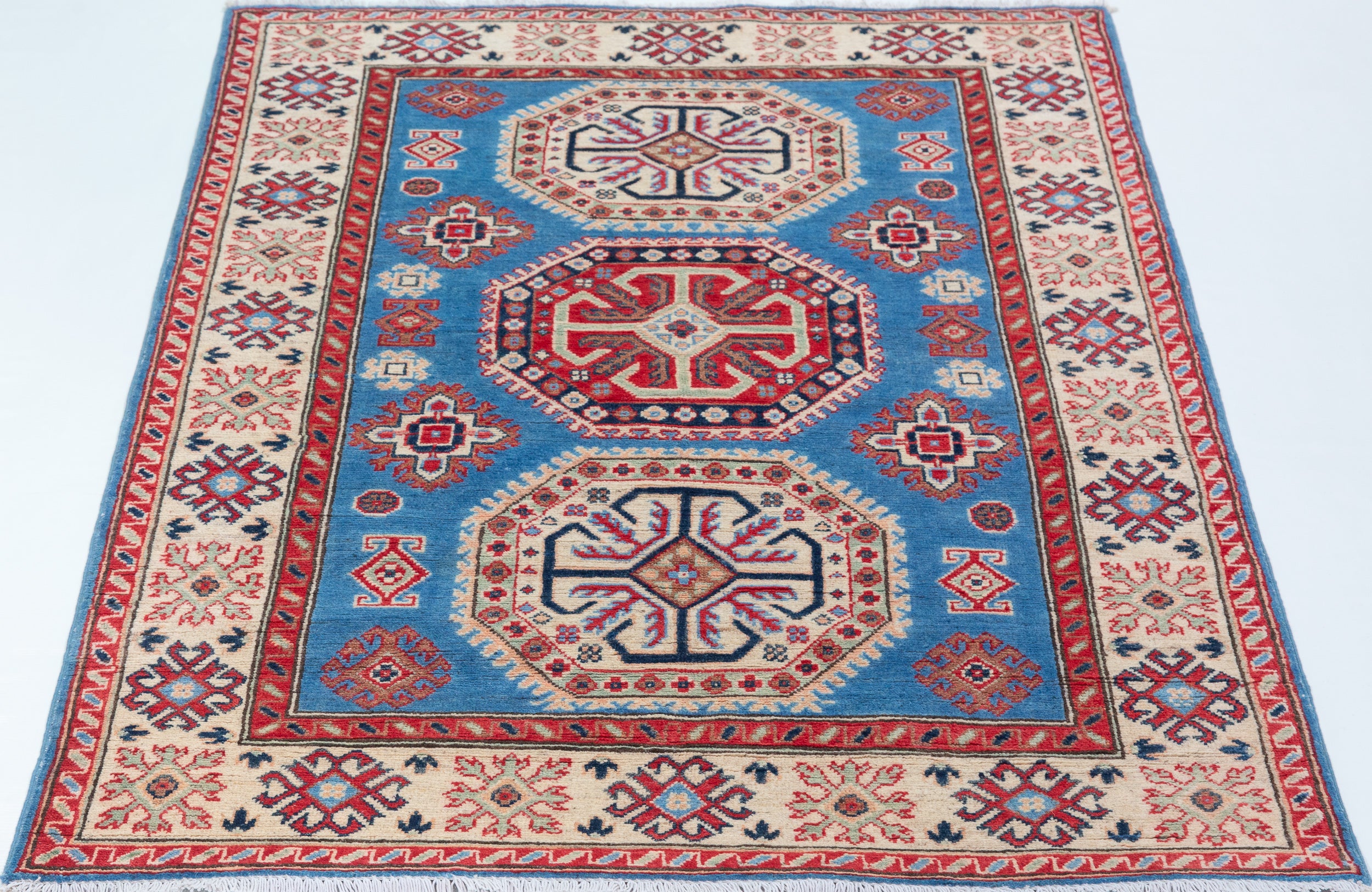 Full view from a low angle of blue & red Kazak-inspired wool rug 29648.