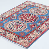 Full view at an angle of blue & red Kazak-inspired wool rug 29648.