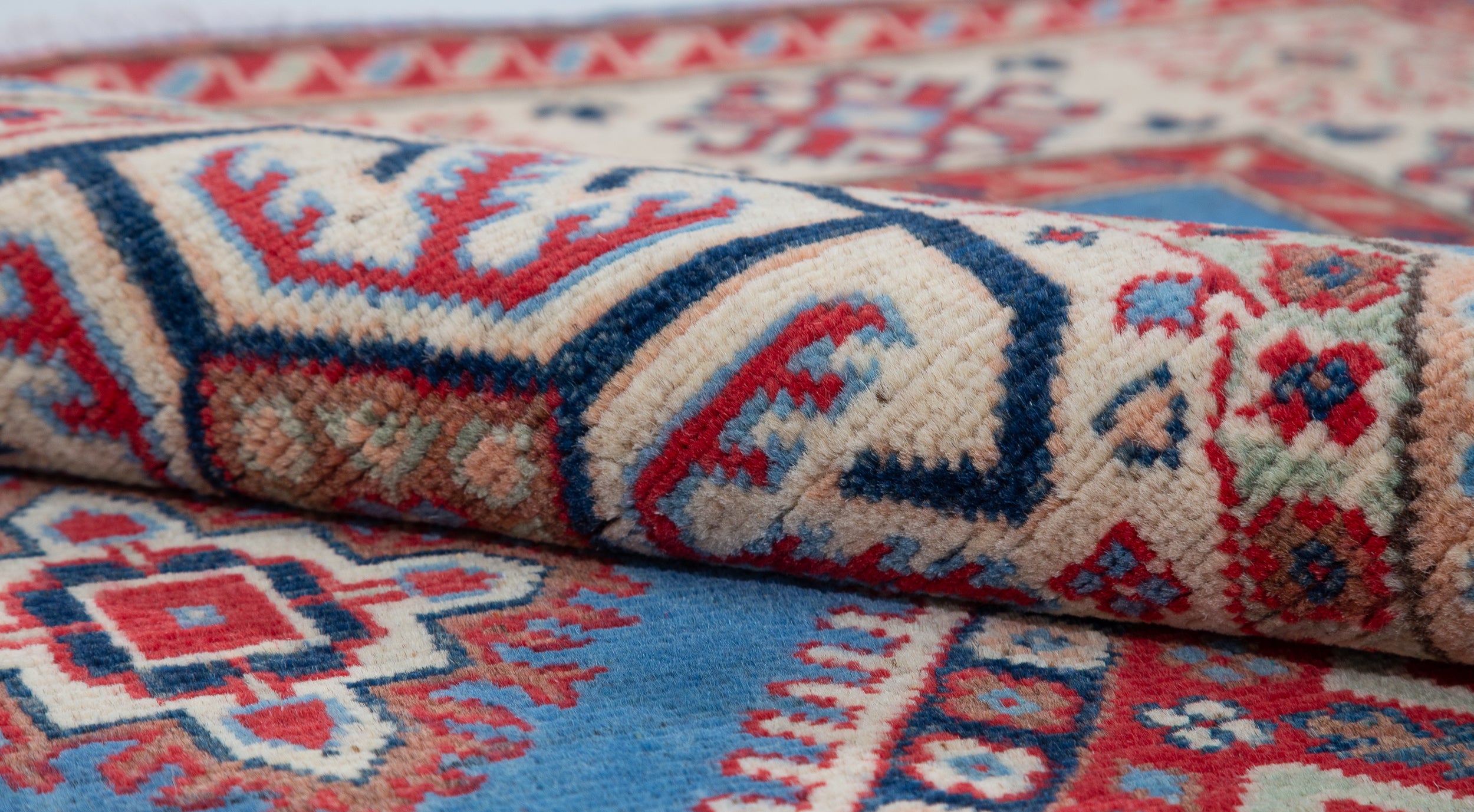 Folded edge and wool pile of blue & red Kazak-inspired wool rug 29648.