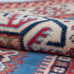 Folded edge and wool pile of blue & red Kazak-inspired wool rug 29648.