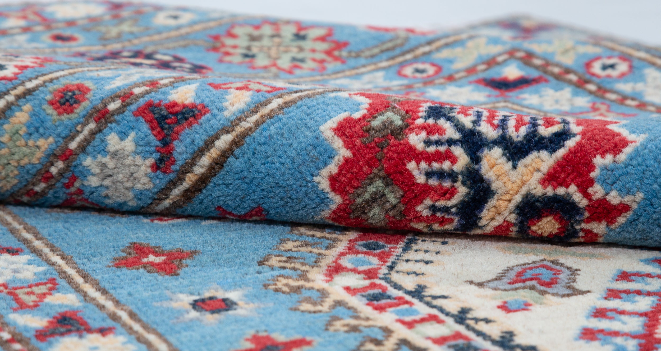 Folded edge and wool pile of blue & ivory Kazak-inspired wool rug 29650.