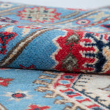Folded edge and wool pile of blue & ivory Kazak-inspired wool rug 29650.
