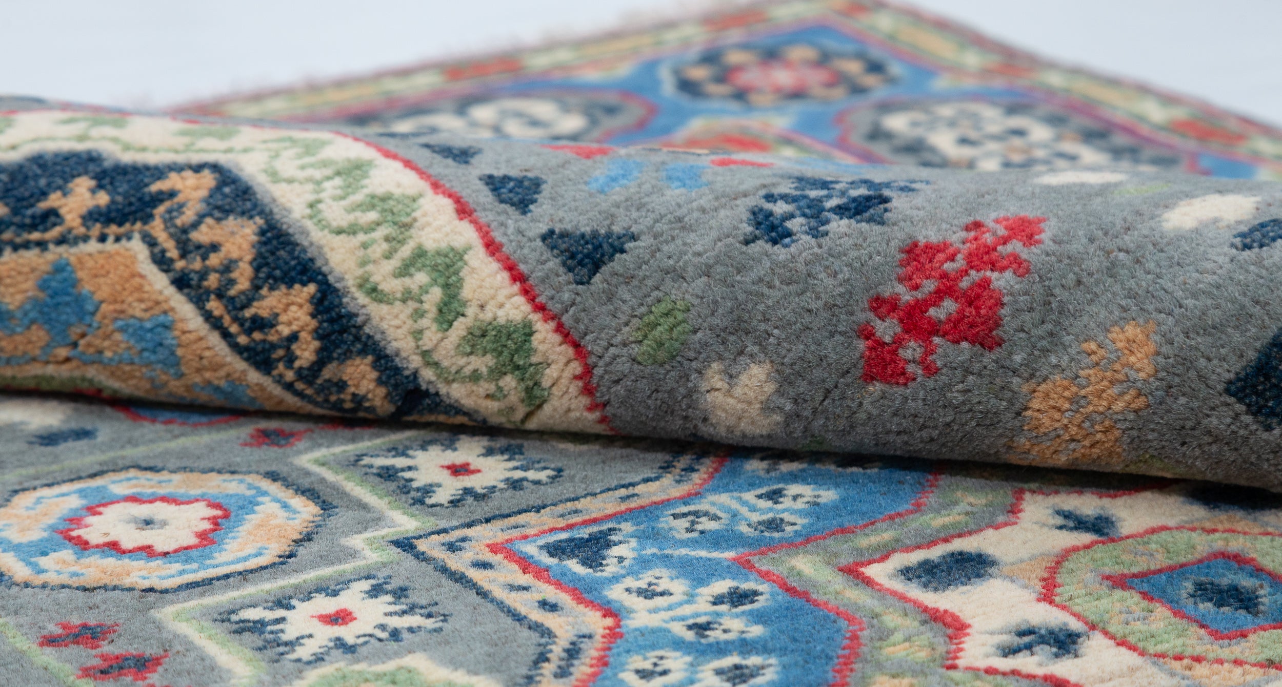 Folded edge and wool pile of blue & ivory Kazak-inspired wool rug 29651.