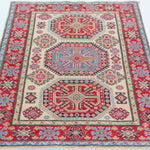 Full view from a low angle of ivory & red Kazak-inspired wool rug 29652.