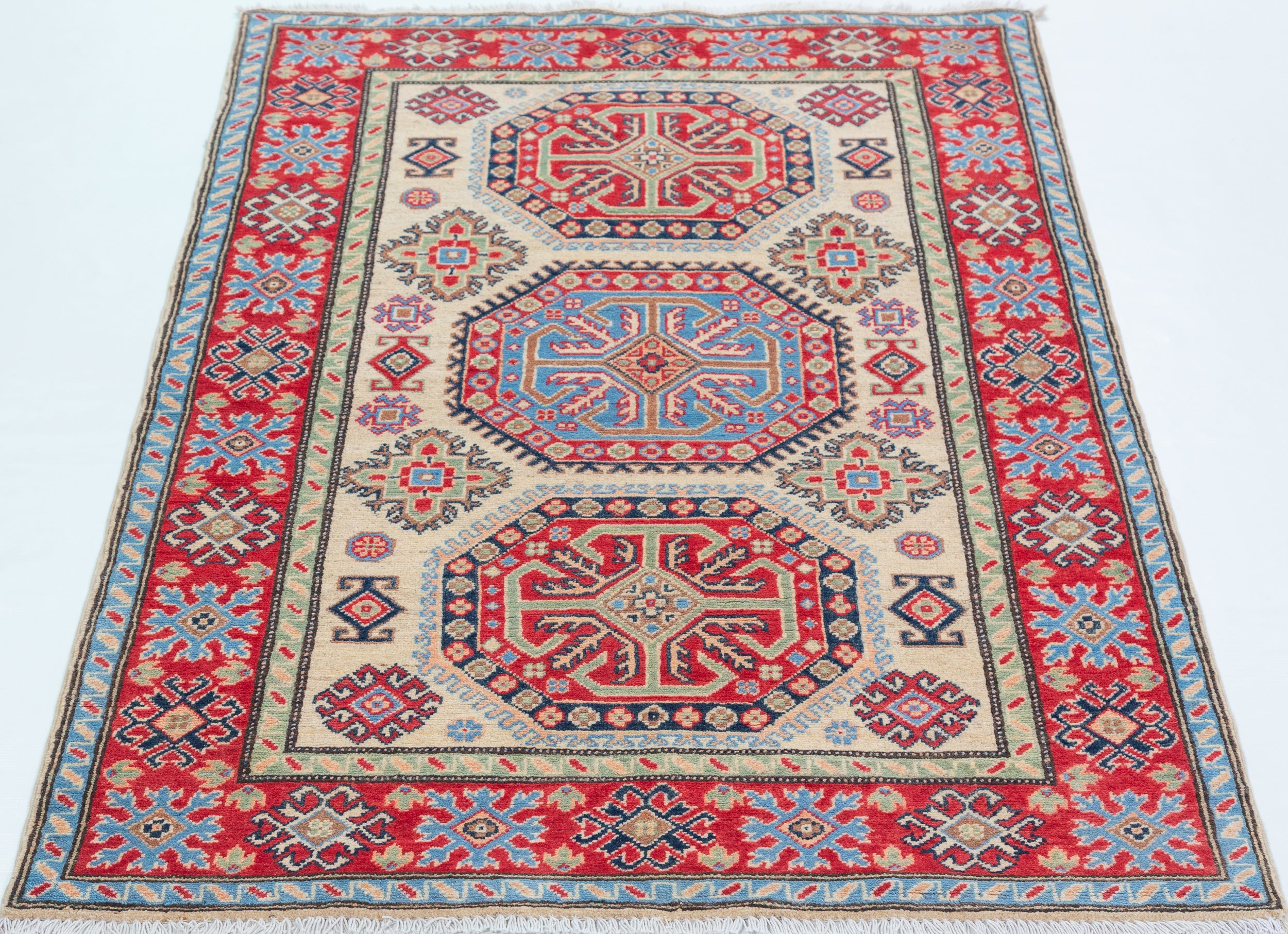 Full view from a low angle of ivory & red Kazak-inspired wool rug 29652.
