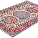 Full view at an angle of ivory & red Kazak-inspired wool rug 29652.