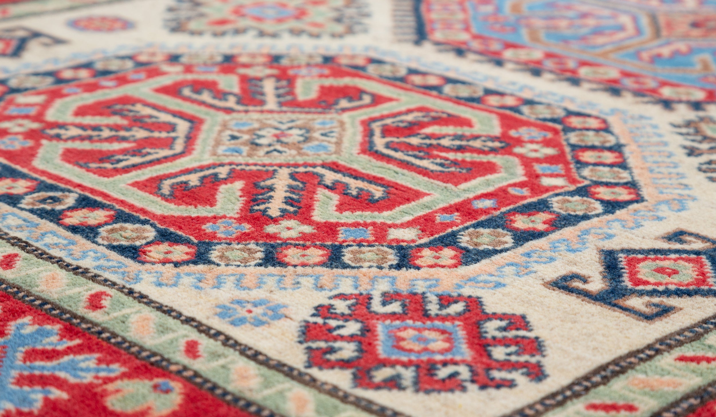 Pattern detail of ivory & red Kazak-inspired wool rug 29652.