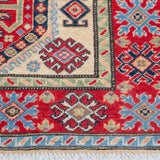 Border and edge detail of ivory & red Kazak-inspired wool rug 29652.