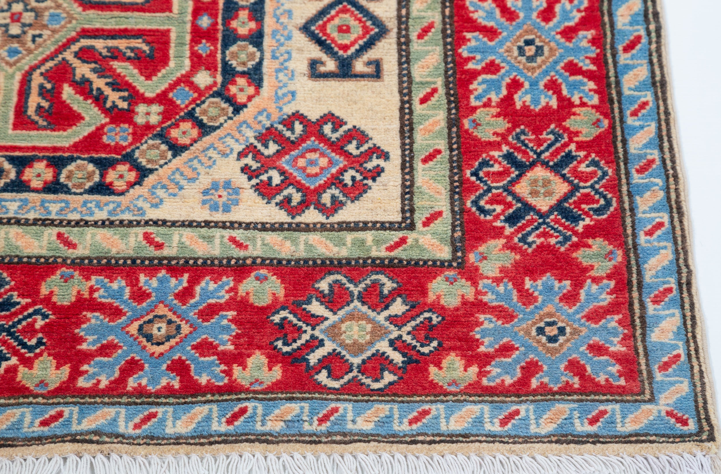 Border and edge detail of ivory & red Kazak-inspired wool rug 29652.