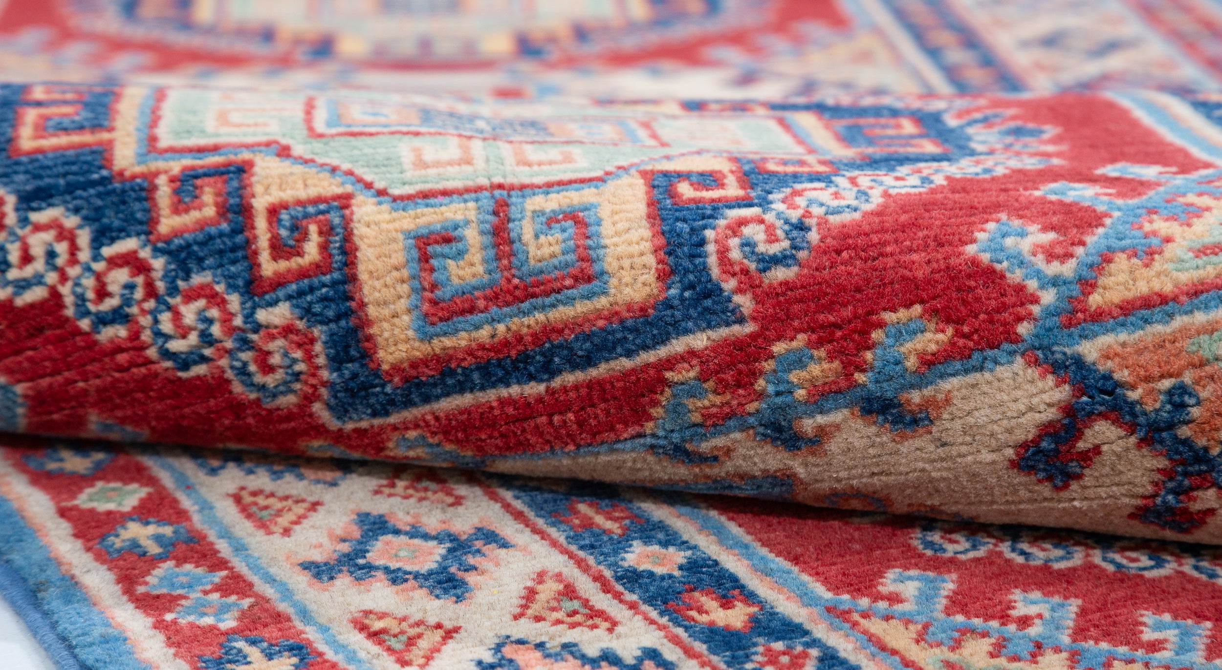 Folded edge and wool pile of blue & red Kazak-inspired wool runner 29656.