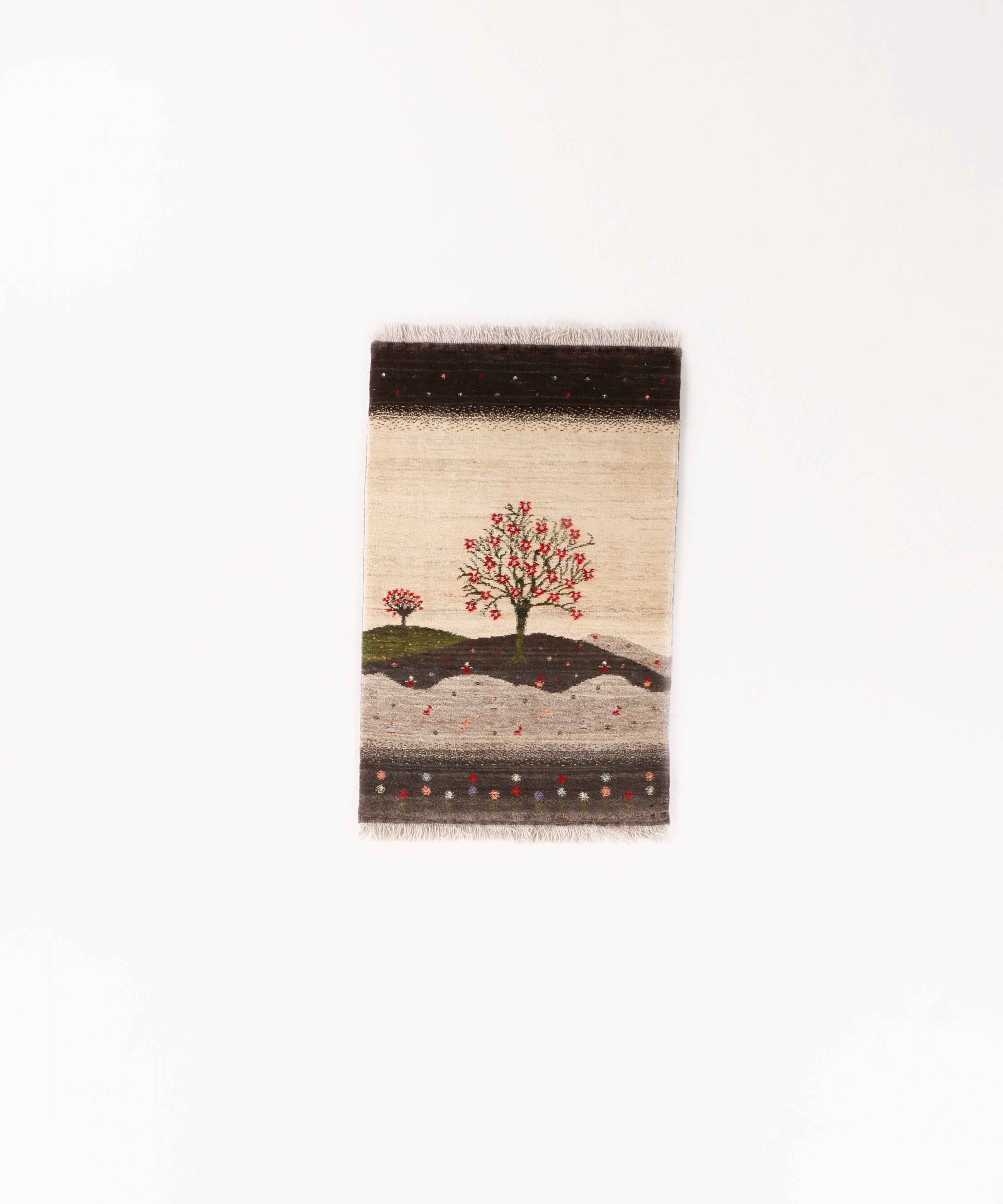 Persian Gabbeh rug with small landscape tree motif, dark top border, and fringed bottom