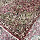 Persian Tabriz rug angled view with dusty rose layout, ivory border, and dense floral design