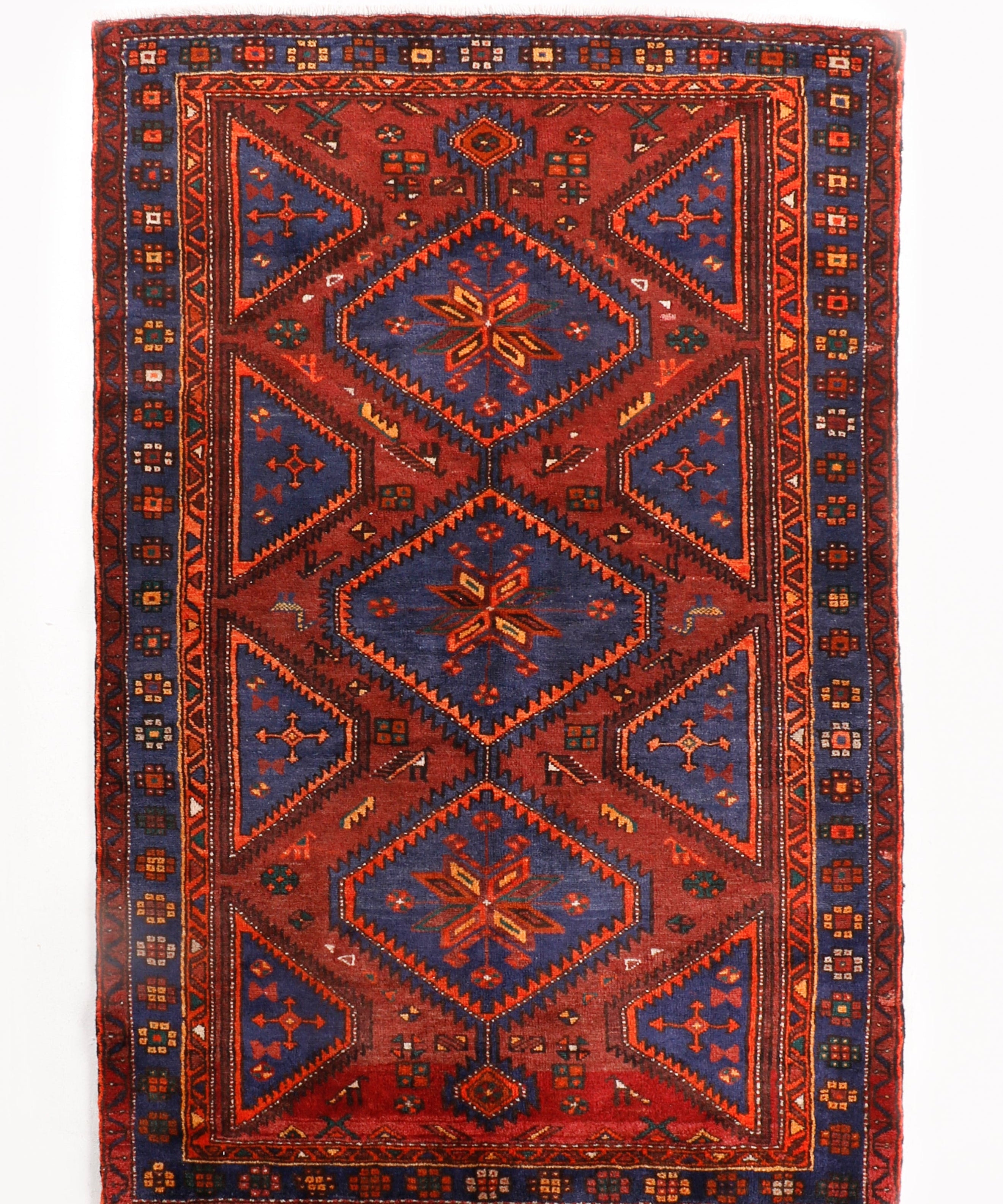 Persian Hamadan rug with red center medallion, navy corners, and patterned border