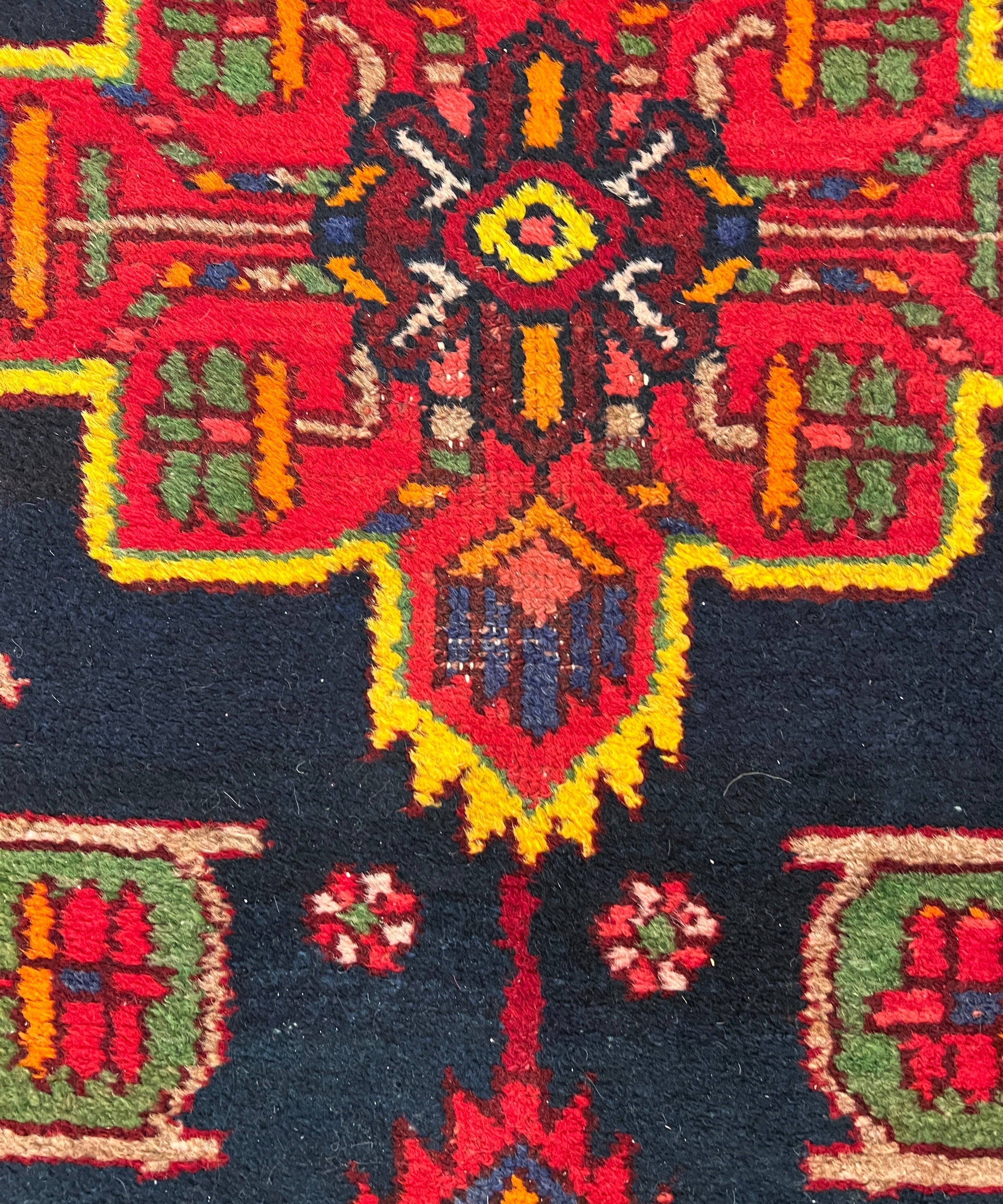 Navy Persian runner rug with red, green, and yellow geometric medallion pattern