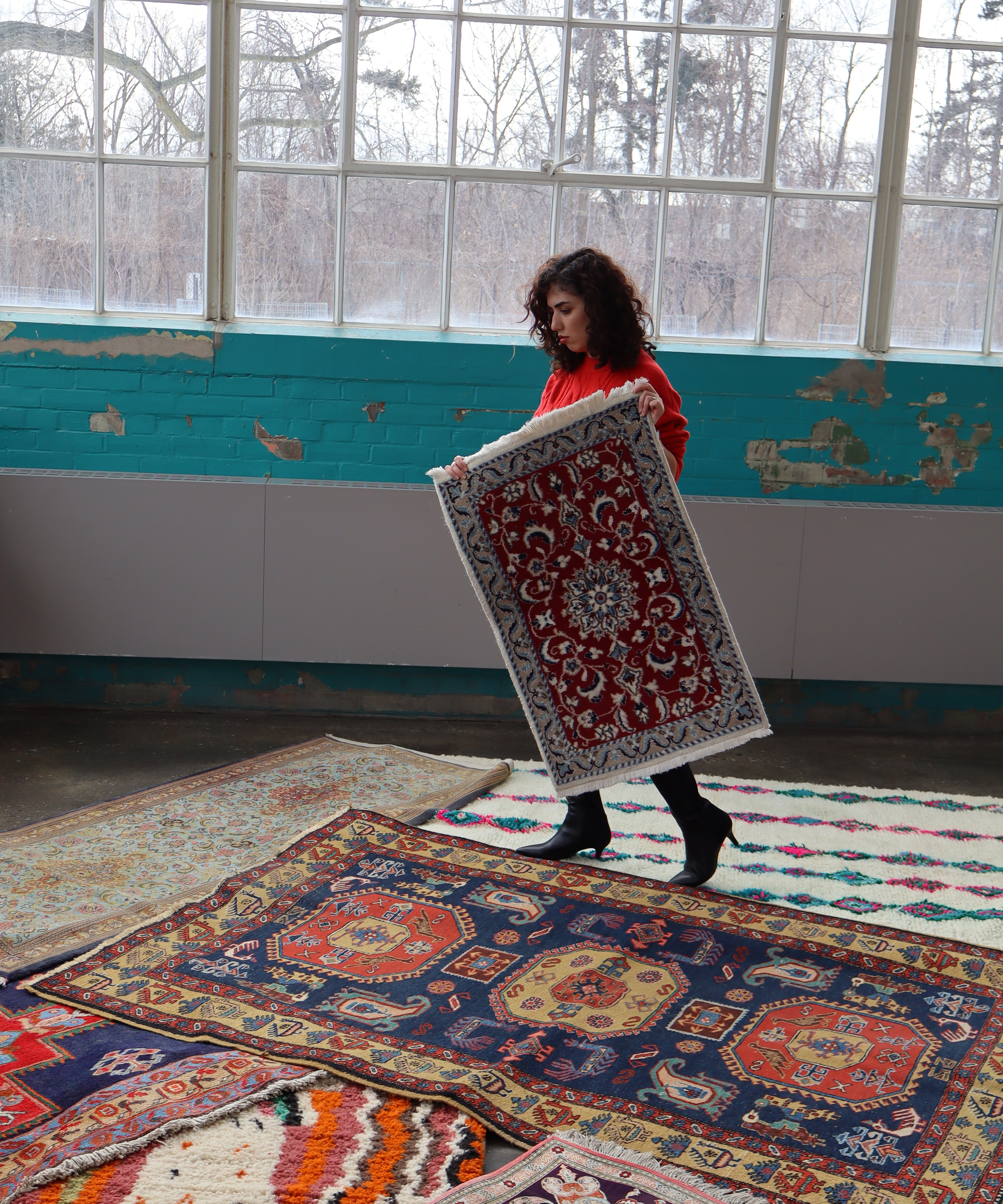 Persian Nain rug laid flat, red medallion center with blue border and cream fringe