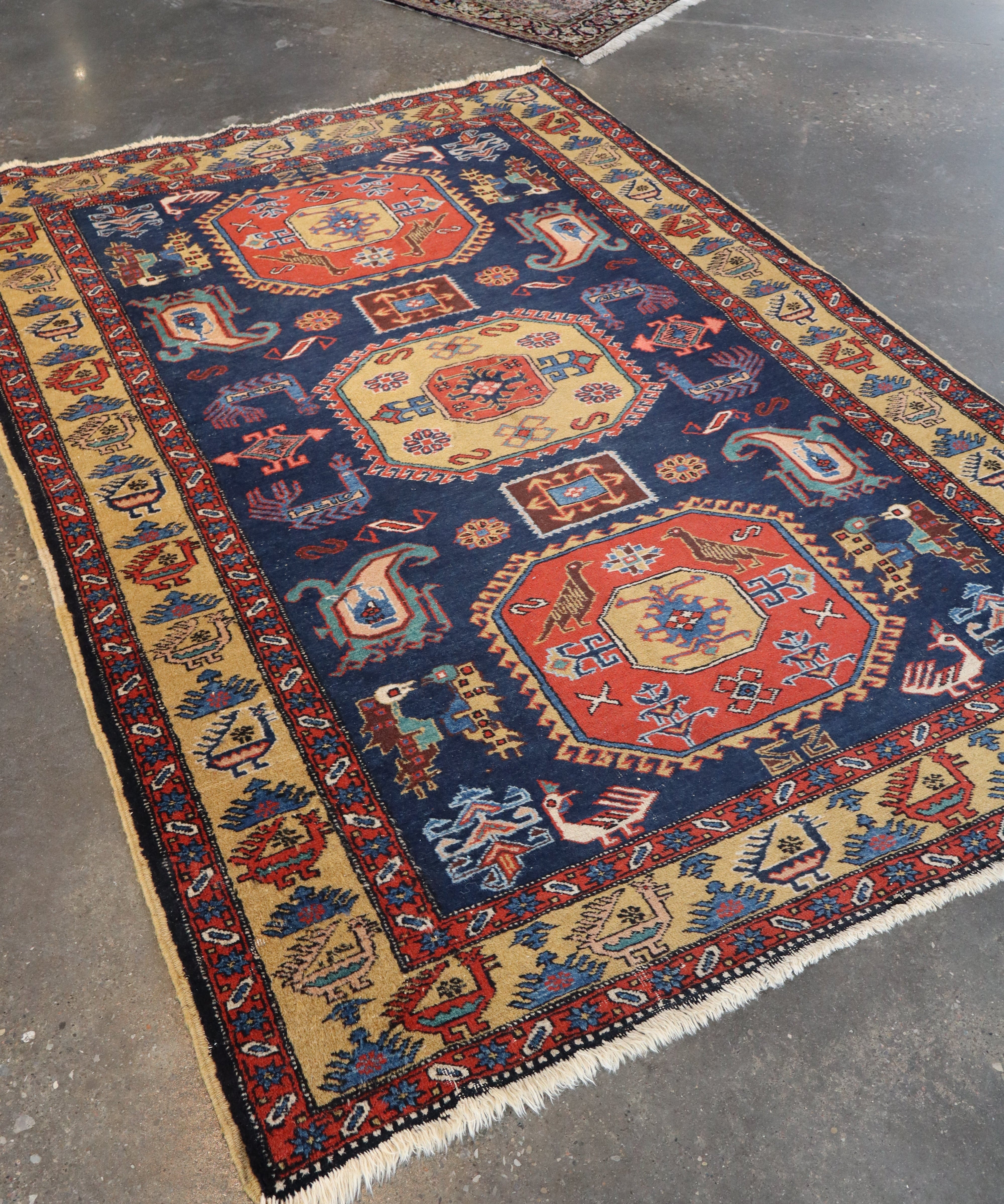 Persian mesh rug with navy field, red and beige medallions, and patterned border