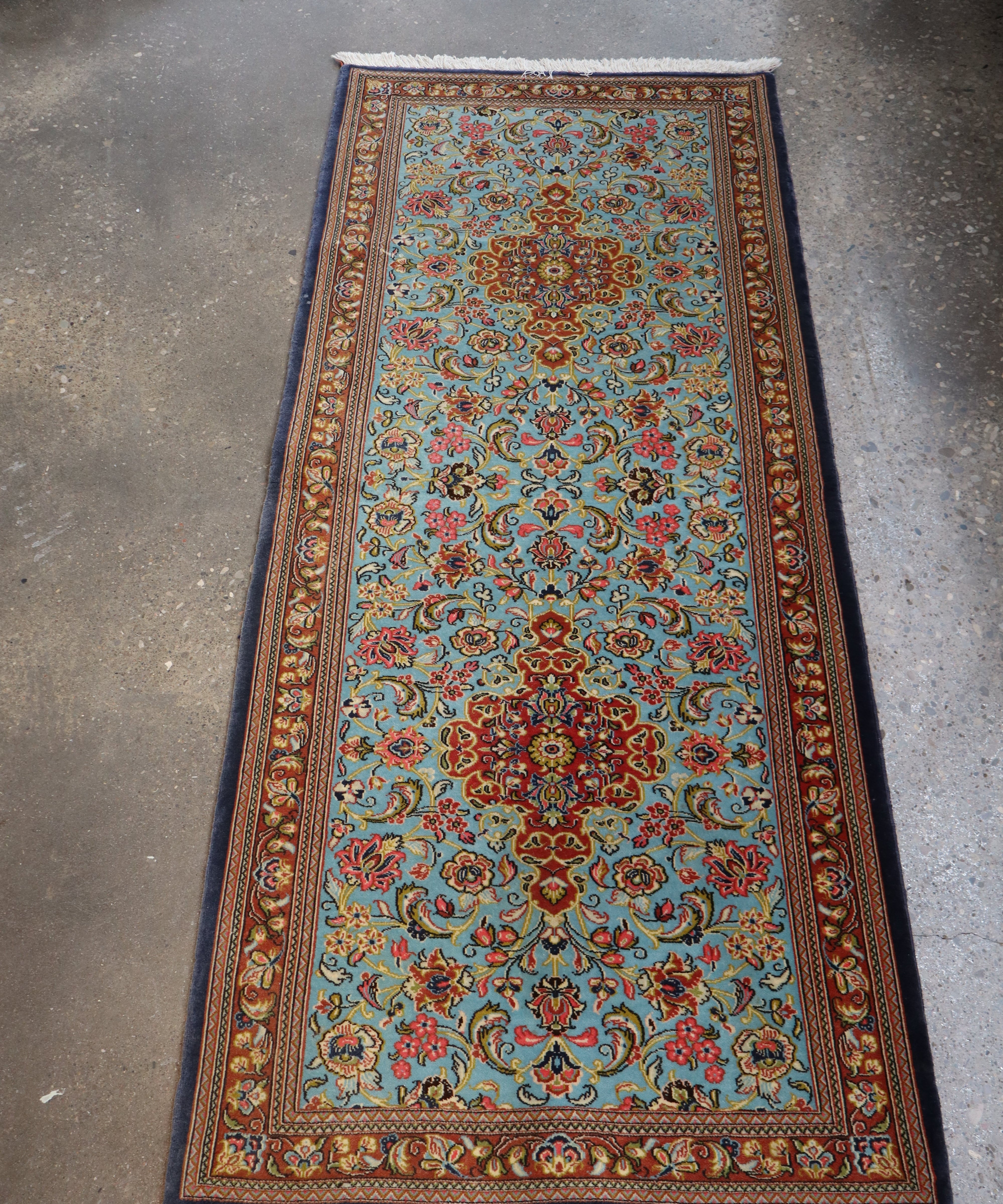 Persian wool runner rug with light blue floral medallion pattern and red border